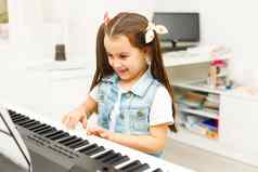 美丽的孩子女孩玩计划生活房间音乐学校学前教育孩子有趣的学习玩音乐仪器教育技能概念