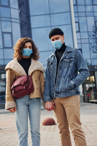 夫妇保护面具走在户外城市业务建筑检疫时间概念冠状病毒