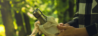 特写镜头认不出来女手持有水瓶生态袋横幅可重用的钢热水瓶公园可持续发展的生活方式塑料免费的浪费免费的生活绿色女人喝水公园