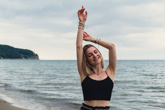 年轻的女人站模糊海滨背景有吸引力的女享受走海海岸旅行活跃的生活方式概念春天放松青年爱生活方式孤独自然健康幸福精神健康和平慢生活