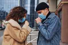 夫妇保护面具咳嗽在户外城市业务建筑检疫时间概念冠状病毒