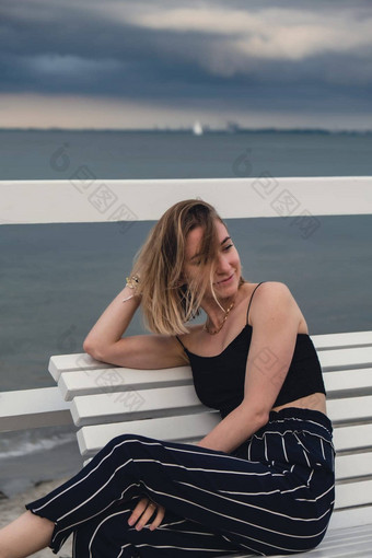 年轻的女人坐着板凳上木码头模糊海滨背景有吸引力的女享受海海岸旅行活跃的生活方式概念春天健康幸福精神健康和平慢生活