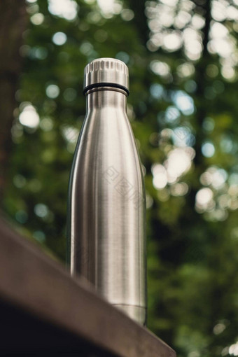 水瓶可重用的钢热水瓶木板凳上等角概念可持续发展的生活方式塑料免费的浪费免费的生活绿色环境保护