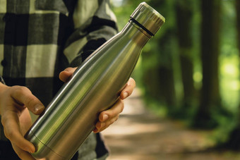 特写镜头认不出来女手持有水瓶可重用的钢<strong>热水</strong>瓶公园可持续发展的生活方式塑料免费的浪费免费的生活绿色女人<strong>喝</strong>水公园