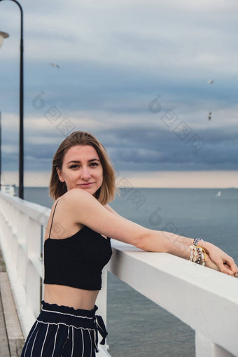 年轻的女人站木码头模糊海滨背景有吸引力的女享受海海岸旅行活跃的生活方式概念春天健康幸福精神健康和平慢生活