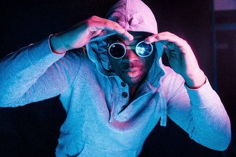 赛博朋克风格眼镜未来主义的霓虹灯照明年轻的非洲美国男人。工作室