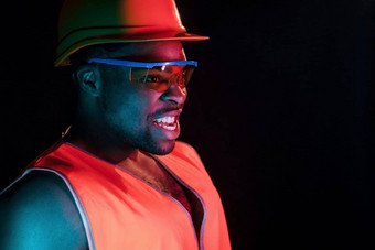 建设工人统一的硬他未来主义的霓虹灯照明年轻的非洲美国男人。工作室