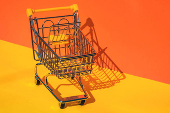 空购物电车车色彩斑斓的橙色黄色的背景复制空间文本在线购物买购物中心市场商店消费者概念小玩具超市杂货店推车食物危机不断上升的食物成本杂货店价格