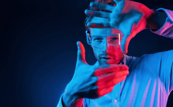 虚拟现实概念霓虹灯照明年轻的欧洲男人。黑暗工作室