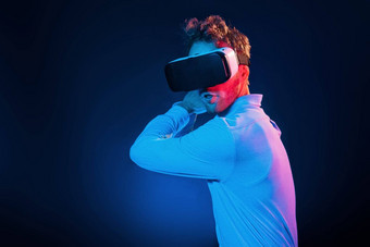 虚拟眼镜游戏经验霓虹灯照<strong>明年</strong>轻的欧洲男人。黑暗工作室