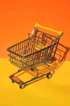 空购物电车车色彩斑斓的橙色黄色的背景复制空间文本在线购物买购物中心市场商店消费者概念小玩具超市杂货店推车食物危机不断上升的食物成本杂货店价格