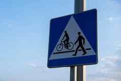 骑自行车的人行人路线分享标志路标志行人自行车交叉街背景蓝色的天空