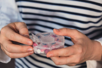 女人排序药片组织者每周照片特写镜头医疗药丸盒子剂量平板电脑每天医学白色粉红色的药物胶囊年轻的女人每天维生素首页健康护理疾病治愈
