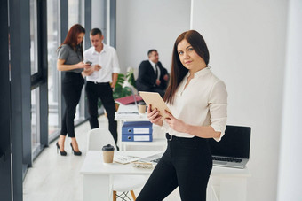 女人持有平板电脑集团人官<strong>方正</strong>式的衣服在室内办公室