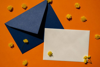 美丽的黄色的洋甘菊雏菊花邮政蓝色的信封橙色背景空纸请注意复制空间文本春天时间问候卡假期极简主义概念生动的颜色有创意的