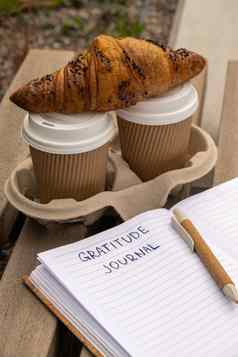 写作感激之情杂志木板凳上咖啡羊角面包早....例程今天感激的发现杂志反射有创意的写作增长个人发展概念幸福精神上的健康考虑到整体健康实践