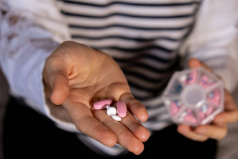女人排序药片组织者每周照片特写镜头医疗药丸盒子剂量平板电脑每天医学白色粉红色的药物胶囊年轻的女人每天维生素首页健康护理疾病治愈