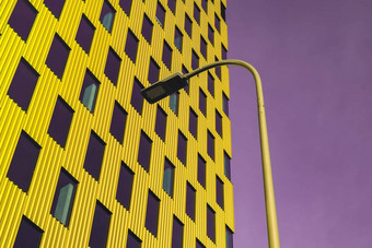 现代办公室建筑外玻璃外观紫色的天空背景生动的颜色透明的玻璃墙办公室建筑黄色的装饰灯笼有创意的照片元素外观现代欧洲建筑商业办公室建筑摘要
