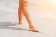 海海滩旅行女人走沙子海滩离开的足迹白色沙子女腿走海边光着脚特写镜头晒黑腿女孩未来水