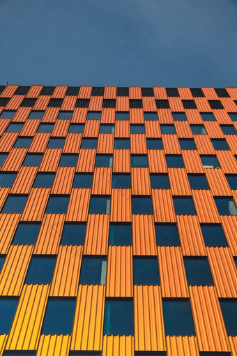 现代办公室建筑外玻璃外观清晰的天空背景透明的玻璃墙办公室建筑橙色装饰元素外观现代欧洲建筑商业办公室建筑摘要