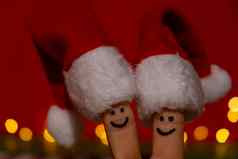 手指穿着圣诞老人的红白帽子快乐手指表情符号脸代表社会网络红色的背景复制空间文本快乐家庭庆祝概念圣诞节年一天手指夫妇