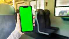女手持有浓度关键屏幕电话火车社会网络工作旅行电话空白复制空间屏幕文本消息应用程序智能手机绿色屏幕模拟显示