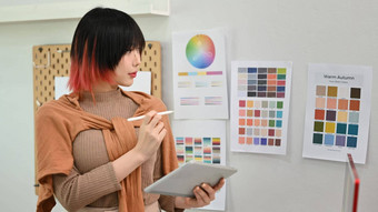 年轻的亚洲女人设计师插画家站现代设计工作室数字平板电脑