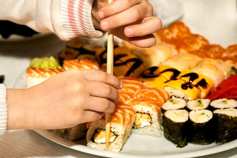 孩子们的手采取美味的寿司筷子孩子吃