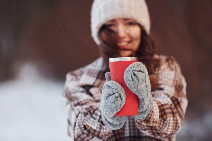 美丽的女人温暖的衣服走冬天森林喝