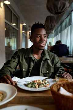 年轻的非洲美国男人。吃餐厅