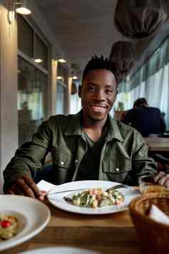 年轻的非洲美国男人。吃餐厅