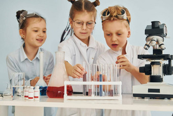 测试管色彩斑斓的液体孩子们白色外套戏剧科学家们实验室设备