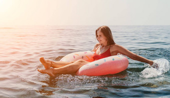 女人夏天海快乐女人游泳充气甜甜圈海滩夏天阳光明媚的一天包围火山山夏天假期概念