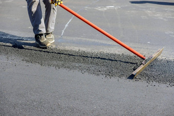 建设工人铺设沥青道路中间过程防潮纸