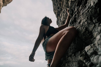 体育女人攀爬岩石年轻的女人苗条的适合身体攀爬火山玄武岩洞穴美丽的海视图运动员女孩火车自然女人<strong>克服</strong>了困难攀爬路线