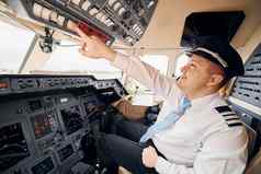 专业工人飞行员正式的穿坐在驾驶舱控制飞机
