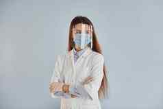 年轻的女医生白色外套站在室内蓝色的背景