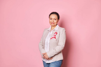 积极的女人穿粉红色的缎丝带显示支持癌症病人乳房癌症一天意识运动