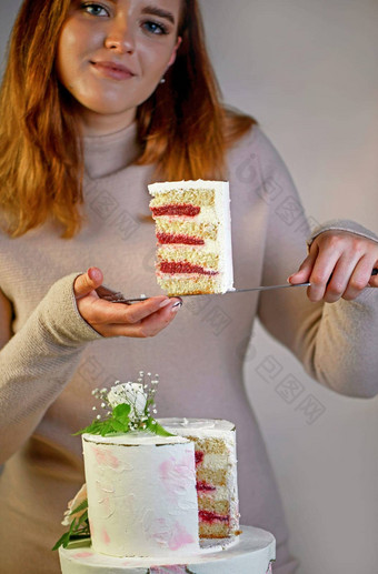 女孩削减服务一块蛋糕节日婚礼两层蛋糕装饰新鲜的花灰色的背景