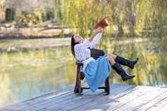 秋天湖女人坐在池塘木码头秋天欣赏自然概念旅游周末城市
