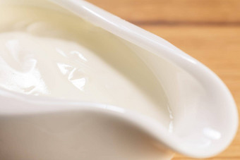白色陶瓷船形调味汁碟新鲜的酸奶油