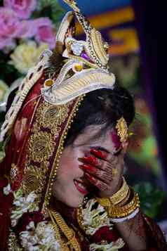 害羞的印度教新娘微笑覆盖脸手传统的印度教婚礼概念美丽的新娘印度教新娘穿红色的纱丽服婚礼皇冠印度教婚礼