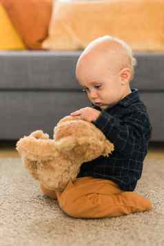 快乐蹒跚学步的男孩玩泰迪熊房子童年孩子发展阶段概念