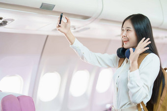 亚洲业务女人乘客坐着业务类奢侈品<strong>飞机</strong>工作聪明的电话移动会说话的<strong>视频</strong>会议旅行概念