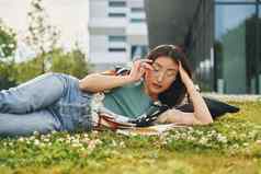 阅读书年轻的亚洲女人在户外白天