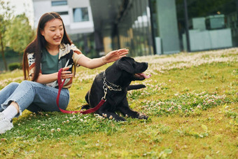 玩<strong>狗年</strong>轻的亚洲女人在户外白天