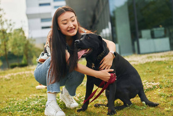 玩<strong>狗年</strong>轻的亚洲女人在户外白天