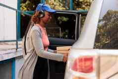 年轻的非洲美国快递交付披萨订单车