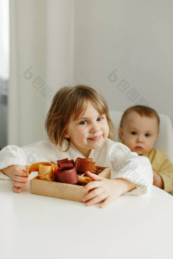 肖像女孩沙拉酱礼服坐在厨房持有盒子<strong>水果糖</strong>果手
