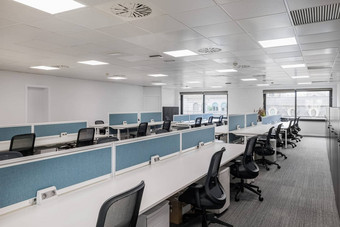 空办公室灰色的音调长表椅子员工经理大窗户自然光概念办公室企业员工共同办公调用中心
